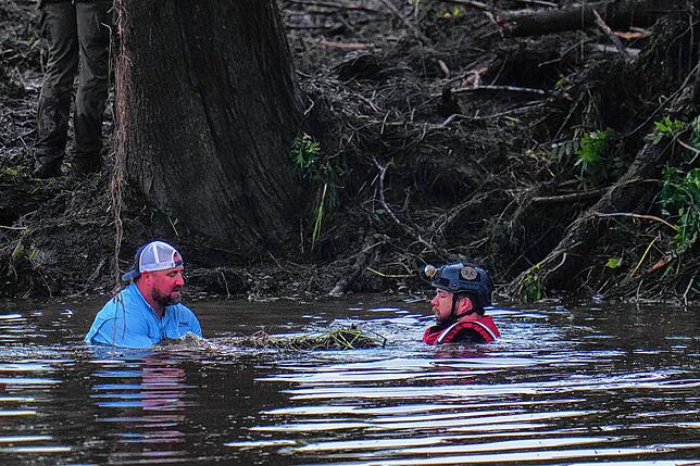 Beamte sind im Guadalupe River zu sehen, während sie bei den Bergungsarbeiten nach der Sturzflut helfen.