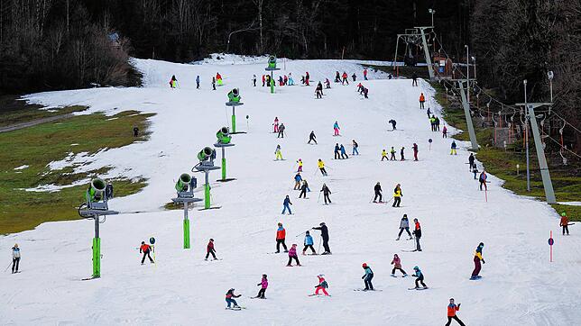 Wintersportler fahren am Streidhang im Skigebiet Brauneck über die Piste. Nicht nur in Bayern leiden viele Skigebiete unter Schneemangel.