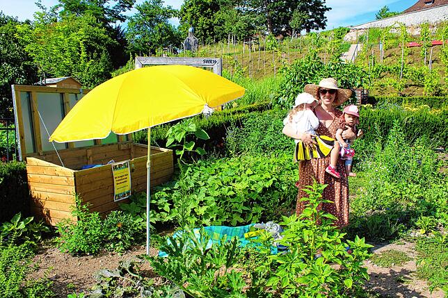 Janna Schmitt steht mit ihren Töchtern Frieda und Emilia in der 55 Quadratmeter großen Parzelle in den Menzingergärten. Das Bild ...