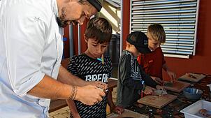 Der gelernte Koch und Küchenchef Niklas Osner (links) erklärte Schritt für Schritt den sicheren Umgang mit dem Messer, hier mit Jakob, ...