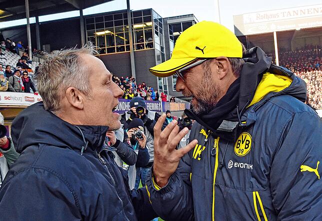 Der Dortmunder Trainer Jürgen Klopp (r) und der Freiburger Trainer Christian Streich unterhalten sich vor Spielbeginn. (Archivbild)