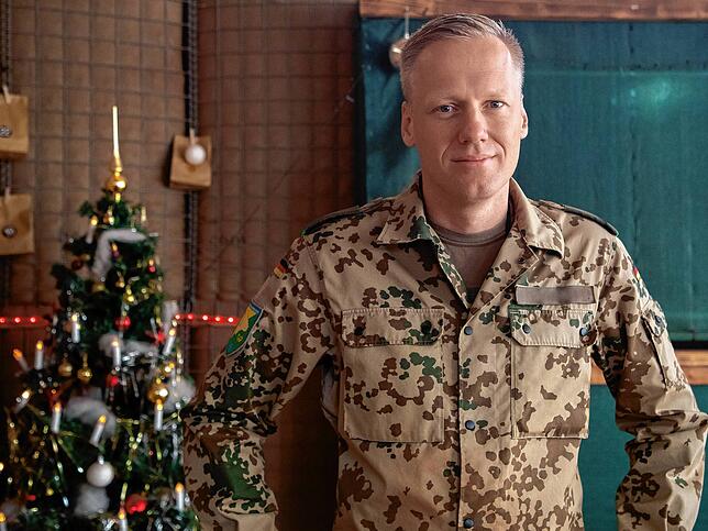 Oberstleutnant Timo Elbertzhagen vom Jägerbataillon 292 steht in Mali vor einem geschmückten Christbaum.