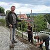 Thomas Kress (links) zeigt, wie ein Weinsetzling aussieht, bevor er von Leonhard Ehrlinspiel (Mitte) und Martin Lemke eingepflanzt und ...