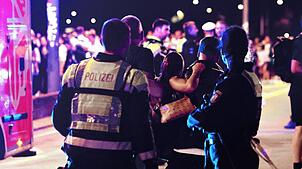 Ersthelfer und Polizisten tragen eine Verletze zu den Sanitätern auf einer Brücke. Ein Feuerwerkskörper explodierte in zu niedriger Höhe ...