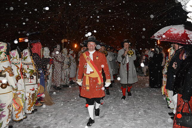 Bei Schneetreiben marschiert die Bräunlinger Stadtkapelle durch das Spalier der Narren in den Narrenschopf ein.