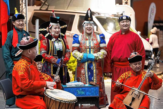 Menschen in traditioneller mongolischer Bekleidung auf der CMT. Die Mongolei ist Partnerland der Messe.