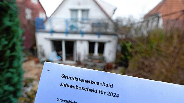 Böses Erwachen für die Bewohner? Ein Grundsteuerbescheid für das Jahr 2024 wird vor einem bebauten Privatgrundstück in Stuttgart ...