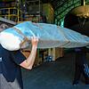 Eine Lieferung Längsträger: Das Bauteil, das die beiden Mitarbeiter hier geschultert haben, wird im Zeppelinhangar sicher deponiert und ...
