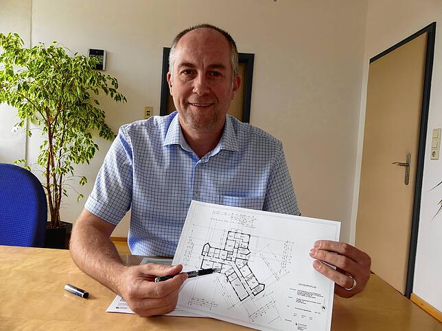 Bürgermeister Maik Lehn mit dem Planentwurf für Arztpraxisräume im Erdgeschoss des ehemaligen Pflegeheims Silberdistel. Es zeigt den ...
