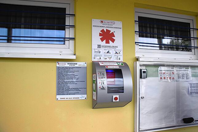In diesem Gehäuse befindet sich am Clubhaus des TSV Bodman ein Defibrillator. Links daneben auf dem Schild stehen die Namen der Spender.