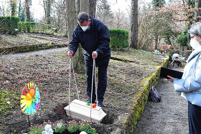Nach einer kurzen Andacht von Klinikseelsorgerin Waltraud Reichle (rechts) lässt Friedhofsmitarbeiter Frank Göller den kleinen Sarg in ...