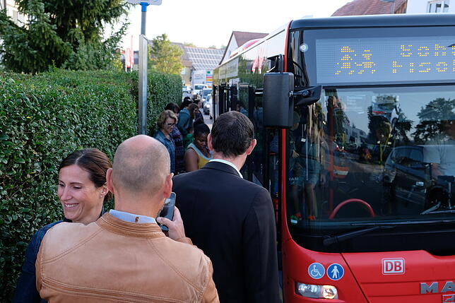 Beim Einsteigen in den Schulbus wird es richtig eng auf dem schmalen Gehsteig zwischen Bus und Hecke.