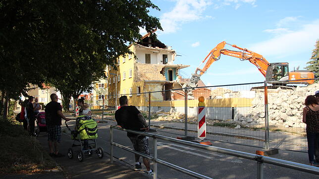 Anwohner haben sich in der Eintrachtstraße versammelt und verfolgen, wie das Haus Nummer&nbsp;18 nach und nach abgerissen wird.