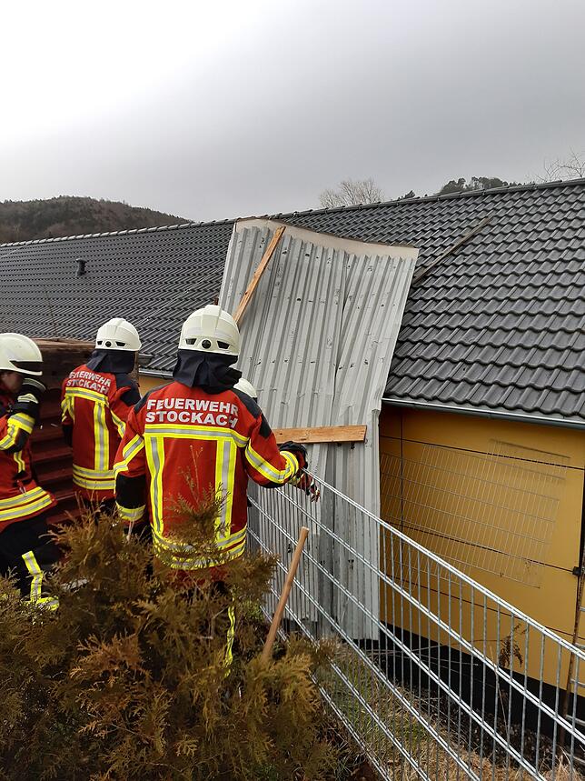 Einsatzkräfte der Stockacher Feuerwehr sichern ein Blechdach, das auf den Zizenhausener Kindergarten geweht worden war.