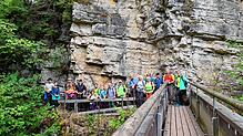 Imposant ragt eine Felswand über die Wutach bei der „ Drei-Schluchten- Wanderung“ 2024, mit Wanderleiter Bruno Matt, hinter der Gruppe ...