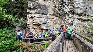 Imposant ragt eine Felswand über die Wutach bei der „ Drei-Schluchten- Wanderung“ 2024, mit Wanderleiter Bruno Matt, hinter der Gruppe ...