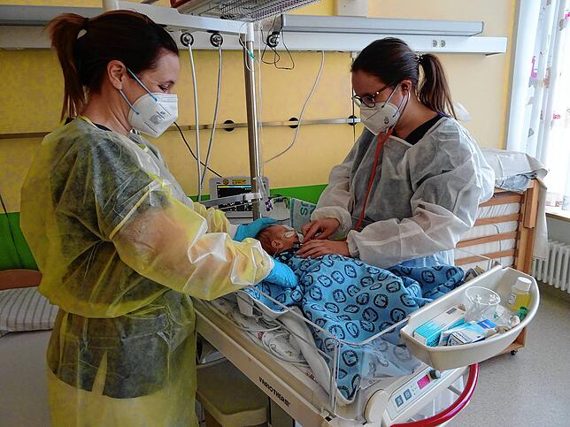 Anja Wernet, Gesundheits- und Kinderkrankenpflegerin und Assistenzärztin Simone Köhler (rechts) untersuchen ein zwei Wochen altes Baby, ...