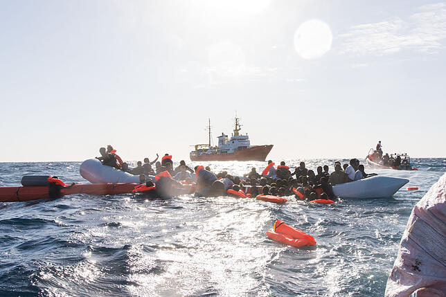 Zahlreiche Flüchtlinge, die auf Booten von Libyen aus nach Italien übersetzen wollten, werden während eines Rettungseinsatzes vor der ...