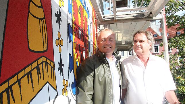 Drei Meter hoch und 2,5 Meter breit ist der Blickfang: Jochen Baur und Peter Meess auf Augenhöhe mit dem Wappen des Hauses ...
