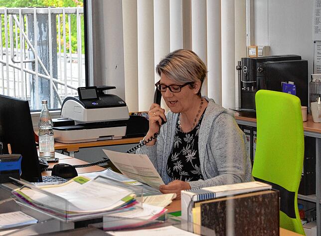 Telefoniert hinter Plexiglasscheibe: Christine Rapp, Sekretärin am Gymnasium.