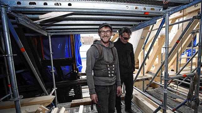 Zwischen verkohlten Balken (links) und den ersten rekonstruierten Teilen des Stadlerhausdachs: Zimmerermeister Florian Kopp und seine ...