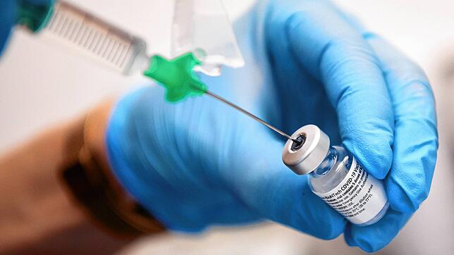 Eine Klinik-Mitarbeiterin zieht den Covid-19 Impfstoff von Biontech/Pfizer für eine Impfung auf eine Spritze.