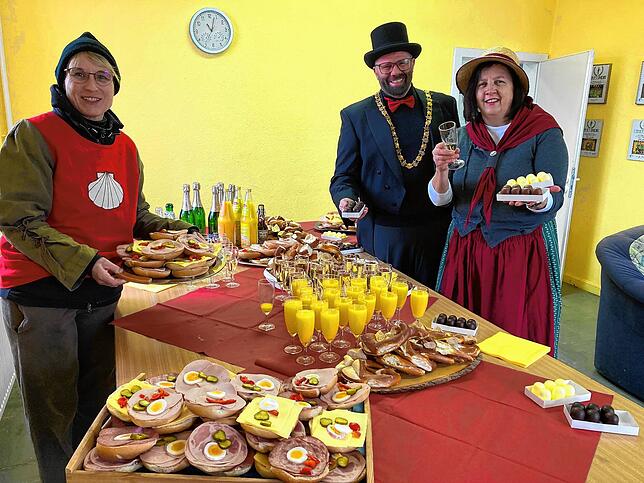 Ortsvorsteher Jakob Krimmel und Elli Schmid und Karin Poisel warten auf die Narren. Das leckere Buffet haben sie schon hergerichtet.