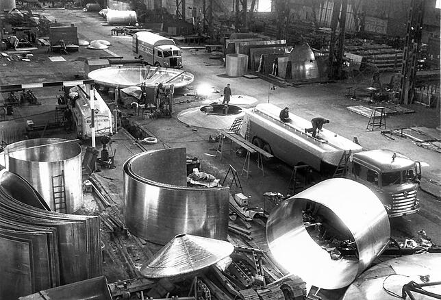 Ein Blick in den Silobau von Zeppelin 1956: Lkw sind in die Halle gefahren, wo die Silowände aus Aluminium gebogen werden. Viele Silos ...