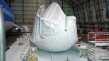 Der Zeppelin liegt nicht auf dem Boden auf, sondern ist so aufgehängt, dass die Hülle über das Gerippe übergestreift werden kann.