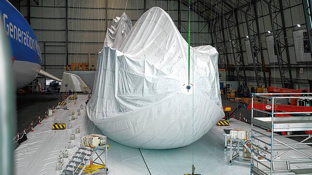 Der Zeppelin liegt nicht auf dem Boden auf, sondern ist so aufgehängt, dass die Hülle über das Gerippe übergestreift werden kann.