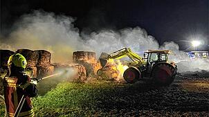 Beim Brand der Riedballen unterstützte der Besitzer des Feldes die Feuerwehr mit seinem Traktor. Er zog das brennende Material ...