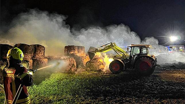 Beim Brand der Riedballen unterstützte der Besitzer des Feldes die Feuerwehr mit seinem Traktor. Er zog das brennende Material ...