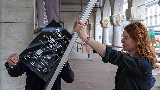 Mitarbeiter entfernen Hinweise zu Corona-Regeln am Eingang des Kunstmuseums in Basel. In der Schweiz sind die meisten ...