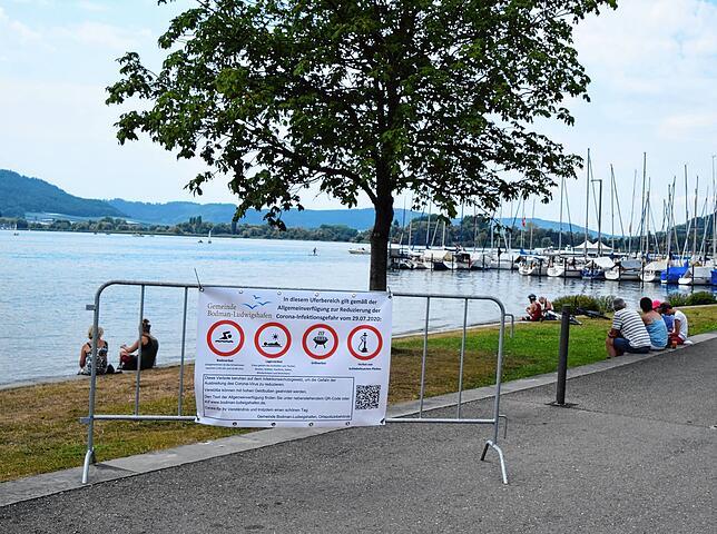 Banner auf Zäune weisen am Ufer in Ludwigshafen auf das geltende Lager- und Badeverbot hin.
