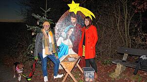 Piera Gürtler (links) und Patricia Mairle am Ende des Weihnachtsweges. Zu sehen sind ein Bild mit Maria und Josef, eine Krippe mit Stroh ...
