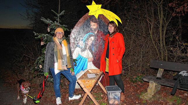 Piera Gürtler (links) und Patricia Mairle am Ende des Weihnachtsweges. Zu sehen sind ein Bild mit Maria und Josef, eine Krippe mit Stroh ...