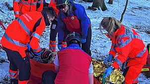 Helfer der Bergwacht Todtmoos und der First Responder Herrischried hüllen das in einem Waldstück verunglückte Mädchen in eine Rettungsdecke.