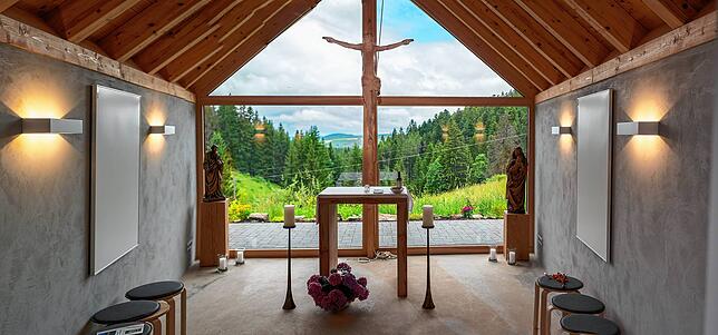 Hinter dem Altartisch öffnet sich durch eine Glasscheibe in der Hofkapelle ein einmaliger Blick über den Schwarzwald bis zur Hornisgrinde.