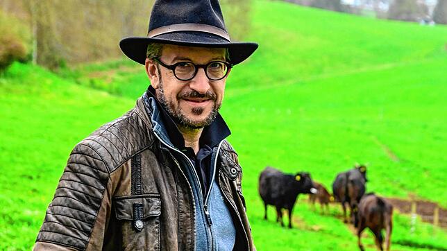 Stephan Peltzer (48) auf der Weide, im Hintergrund stehen Wagyu-Rinder.