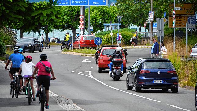 Autofahrer, Fußgänger und Fahrradfahrer begegnen sich in Meersburg auf der Straße zur Fähre und zum Parkplatz.