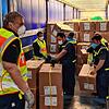 Helfer aus Frankfurt verladen gemeinsam mit THW-Kräften aus Waldshut-Tiengen Material aus einem Flugzeug aus China in die Lastwagen.