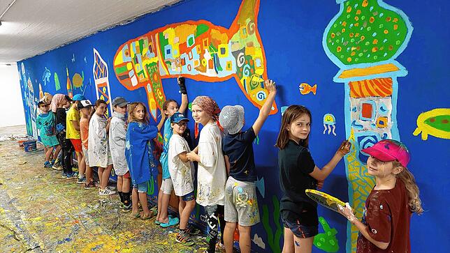 Dass sie mal eine Wand anmalen dürfen, finden die Grundschüler besonders spannend – auch wenn dabei die Farbe nicht nur auf dem ...