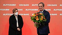 Armin Laschet (r), CDU-Bundesvorsitzender, hält beim Online-Parteitag der CDU Baden-Württemberg ein Blumenstrauß in den Händen, der ihm ...