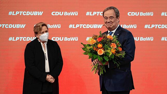 Armin Laschet (r), CDU-Bundesvorsitzender, hält beim Online-Parteitag der CDU Baden-Württemberg ein Blumenstrauß in den Händen, der ihm ...