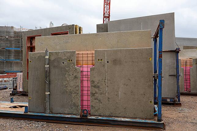 Die Außenwände werden in Fertigbauweise geliefert. Die Aussparungen im Stahlbeton sind für Leitungen vorgesehen.