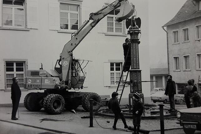 Im Dezember 1972 wurde der alte Adler-Brunnen am Marktplatz abgebaut. Auf dem Bild ist der Trog bereits weg und die Säule wird ...