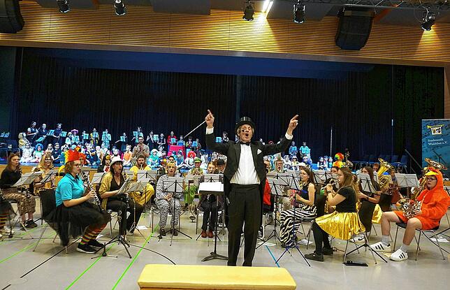 Das große Schlussbild beim Kinderkonzert der Stadtmusik. Dirigent Frank Amrein auf der Bühne mit dem Nachwuchsorchester und ...