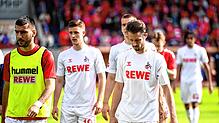 Die Kölner Spieler gehen nach der Niederlage vom Rasen.