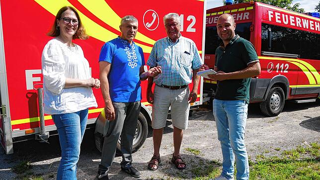 Passend vor einem Feuerwehrauto (von links): Übersetzerin Viktoria Myrohenko, Feuerwehrkommandant Viktor Popruga, Wolfgang Werkmeister ...