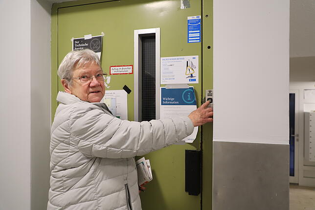 Gudrun Köthen drückt – hier nur symbolisch – den Rufknopf des Aufzuges, der seit Dezember defekt ist.